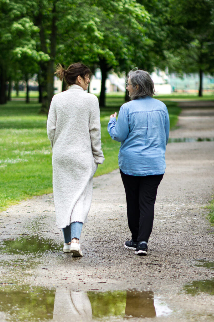 Martina Serlath geht mit einer Patientin auf einem Schotterweg und spricht über nterkühlte Ehe & Streit in der Beziehung